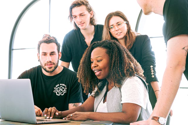 A group of people looking at a laptop screen